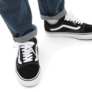 Vans Oldskool Schuhe in Schwarz mit weißen Schnürbänder und Seitenstreifen werden getragen.
