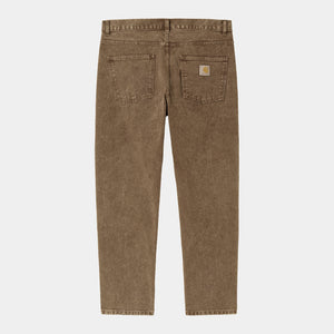 klassische 5 Pocket Jeans in braun gefärbten und runtergewaschenen Material mit weiten nach unten hin schmal zulaufenden beinen und carhartt logo auf der gesäss tasche
